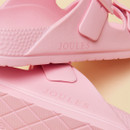 Close-up of stacked light pink sandals highlighting the embossed Joules logo and textured strap and sole details.