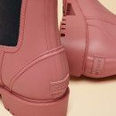 Close-up of the heel and side panel of the pink Chelsea-style rain boots, highlighting the stitching details and embossed Joules logo.