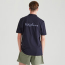 Rear view of a young man wearing a navy Ridgeline polo shirt with large Ridgeline script branding across the back.
