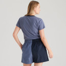 Back view of a woman wearing a blue Ridgeline T-shirt and two-tone navy shorts, showing the contrasting fabric split and elasticated waistband.