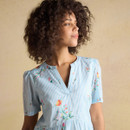 Close-up of the upper bodice of a light blue striped floral dress with a soft V-neck and delicate floral detailing.