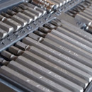 Close-up of an organized set of metal drill bits in a case, varying in size with engraved numbers. The image conveys precision and readiness.