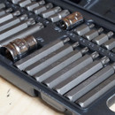 A set of silver metallic Torx bits arranged neatly in a black plastic case. The bits are labelled with sizes, conveying organization and precision.