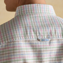Close-up of the back collar on a men’s Oxford shirt showing multicoloured check fabric and Joules embroidered label.