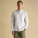 Front view of a model wearing a men’s white multicoloured check Oxford shirt styled with green chinos.