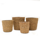 A view of a larger, medium, small and extra small seagrass round pots on a white background