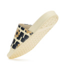 Cream slide sandal showing textured outsole and patterned strap from below.