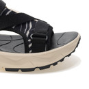 Close-up of black sandal straps and cushioned midsole with textured tread.