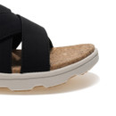 Close-up of black slide sandal showing padded straps and cork footbed texture.