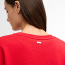Close-up of the back neckline showing the small Barbour metal badge on the red sweatshirt.
