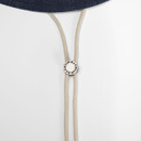 Close-up of the hat’s cream chin cord with round Barbour-branded toggle.