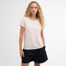 Model wearing a pale pink Barbour T-shirt with rolled sleeves and tonal chest logo, styled with navy shorts.