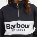 Close-up of the navy half-zip collar with gold zip pull and Barbour logo panel across the chest.