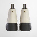 Rear view of cream Barbour Chelsea boots with pull tabs and thick treaded platform soles.