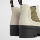 Back detail of cream Barbour Chelsea boots highlighting pull tabs, textured rubber upper and chunky sole.