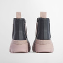 Back view of Barbour navy Chelsea wellington boots with blush pink lug soles and rear pull tabs.
