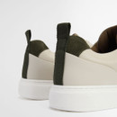 Rear view of Barbour beige trainers featuring green suede heel panel, pull tab and thick white sole.
