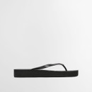 Side profile of black flip flop highlighting thick platform sole and low-profile strap