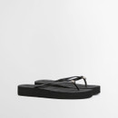 Black flip flops with slim thong straps and thick cushioned sole on a white background