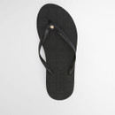 Top view of black flip flop with textured footbed and small metal logo detail