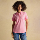 Model wearing a pink short-sleeve Joules polo shirt with a classic collar, button placket and embroidered hare logo, styled with blue jeans.