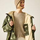 Mid shot of the changing robe worn open to show the cream fleece lining, with a beige ribbed knit jumper underneath.