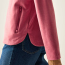 Close-up of the Slate Rose fleece jacket’s zipped side pocket and curved split hem.