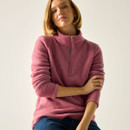 Close-up of a model wearing a pink half-zip fleece top with a high collar, arms folded.