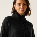 Close-up of the black fleece jacket showing the high collar and chest zip pocket.