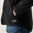 Close-up of the black fleece jacket showing the hand pocket with zip and Regatta Great Outdoors logo patch.