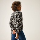 Back three-quarter view of model wearing the cream-and-black floral print fleece jacket.