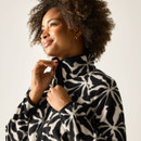 Close-up of model adjusting the high collar on the cream-and-black floral print fleece jacket.