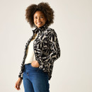 Three-quarter view of model in the cream-and-black floral print fleece jacket, unzipped over a light top, with hand in pocket.