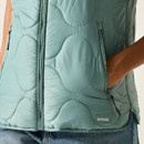 Close-up of the ivy green quilted gilet showing the zip fastening, quilting, zipped pocket and Regatta Great Outdoors logo badge.