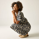 Model crouching in the cream and navy floral print midi dress, showing the relaxed fit and drape of the skirt.