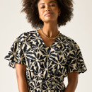 Close-up of the V-neckline and floral print, showing the short sleeves and drawstring tie at the waist.
