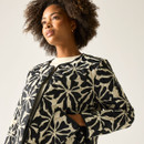 Close-up of cream quilted jacket with black floral pattern, showing the round neckline, popper fastenings and pocket detail.