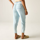 Back view of model wearing light blue chambray trousers showing elasticated waistband and back patch pockets, styled with beige clogs.