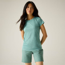 Model wearing a green short-sleeve crew-neck T-shirt with green shorts, standing against a light studio background.