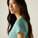 Close-up of the model wearing the green T-shirt, showing the sleeve logo detail.