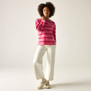 Full-length view of model in pink and red striped long-sleeved top with white trousers and trainers.