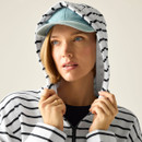 Close-up of model in a white and navy striped hoodie with hood up and drawcords, wearing a cap.