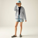 Full-length view of model wearing a white and navy striped zip-up hoodie with denim shorts and cap.