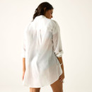 Back view of model wearing a sheer white long-sleeve shirt cover-up, studio background.