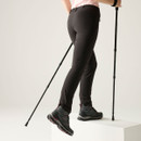 Back view of black women’s walking trousers worn with hiking boots, showing the slim leg fit.