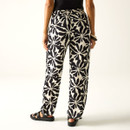 Back view of black and cream printed trousers worn with sandals.