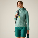 Model wearing a green insulated hooded jacket with matching green shorts, carrying a backpack and water bottle.