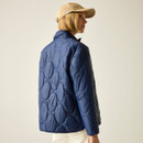 Rear three-quarter view of the navy quilted jacket highlighting the circular quilt pattern.