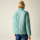 Back view of the green quilted jacket on the model, showing the stand collar and all-over curved quilting.