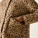 Close-up of the tan leopard-print quilted jacket showing the quilted stitching and front patch pocket.